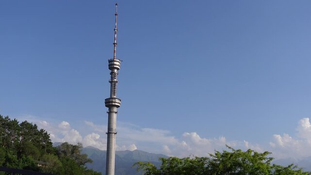 Aerial view of Kok Tob TV tower standing tall against blue sky with mountains in the background