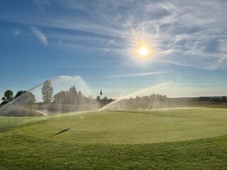 sprinkler spraying water on the golf green