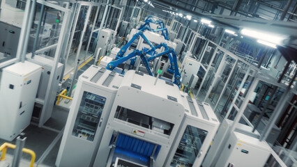 High Tech Factory with Blue Robotic Arms Assembling Electronic Components on a Production Line Conveyor Belt. Automation and Artificial Intelligence in a Modern Manufacturing Process. High Angle