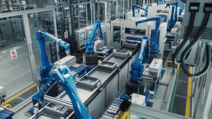 Autonomous Factory with Blue Robot Hands Efficiently Assembling Components on a Production Line, Showcasing Advanced Automation and Precision Engineering in a Modern Manufacturing Plant. High Angle