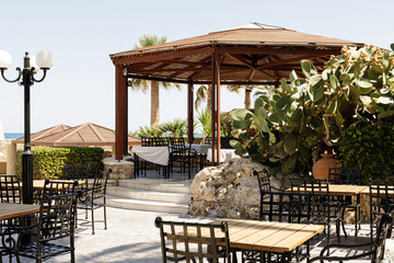 Stock photo of a beautiful outdoor restaurant patio with a wooden gazebo, perfect for summer dining.