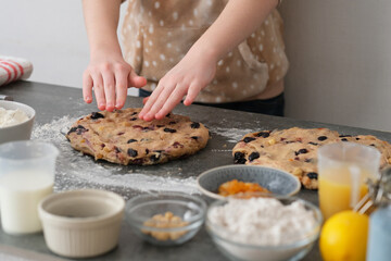 Hands shaping loaves of Christmas Bread or stollen cake are arranged on a table in a kitchen. Holiday traditional baking.