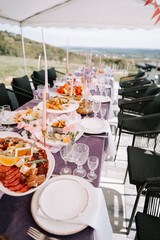 Outdoor dining setup with a variety of dishes and elegant table setting in a scenic location