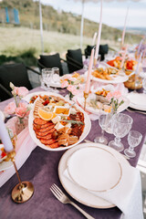 Elegant outdoor dining experience with a beautifully arranged gourmet spread and floral decor