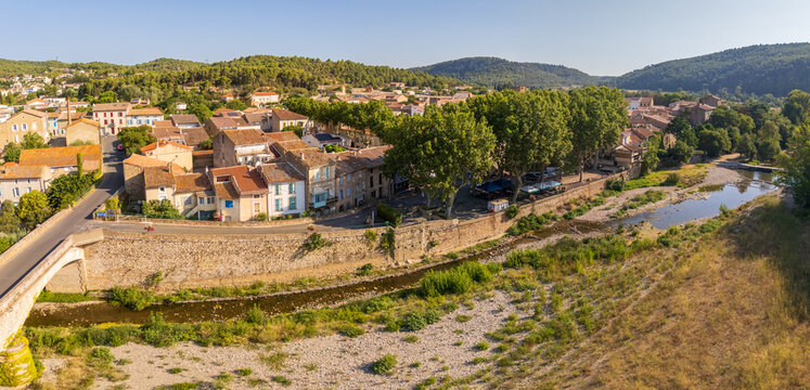 Panorama of Bize-Minervois and the river Cesse, in Occitanie, France, with typical southern french houses in beige and terracotta colors, early summer morning