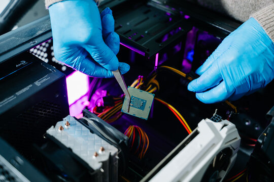 The technician is putting the CPU on the socket of the computer motherboard. electronic engineering electronic repair, electronics measuring and testing, repair - Powered by Adobe