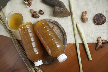 Plastic bottle containing fresh herbal drink with spices in a mortar. Traditional health drink made from natural ingredients. Top view (2)