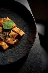 grilled fish dish with spices on a plate on the dining table
