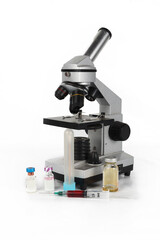 Microscope with blood syringe, vial, and test tube on a white background