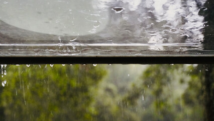 Open Window on Rainy Day with Water Droplets and Nature Background.