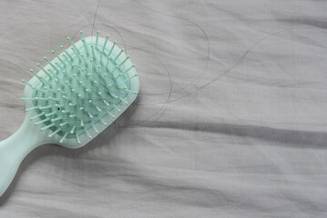 Fallen hair on a cloth with a hairbrush, showing the hair loss problem.