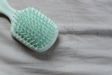 Fallen hair on a cloth with a hairbrush, showing the hair loss problem.