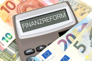 Das Display von einem Taschenrechner ist beschriftet mit Finanzreform über vielen Euro Banknoten...