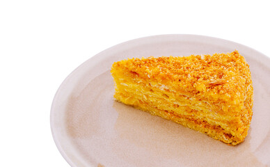 Moist, golden slice of delicious cake on a simple plate with white background