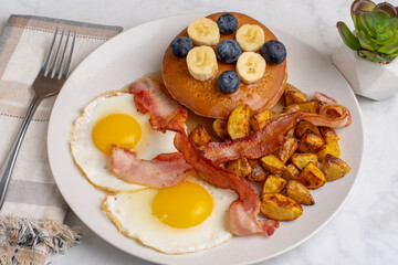 fried eggs with pancakes and bacon