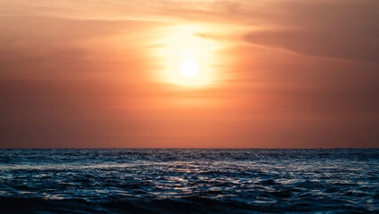 Sunset over ocean, Bali, Canggu. Travel and vacation on the beach near ocean. Sun goes dawn over waves of water