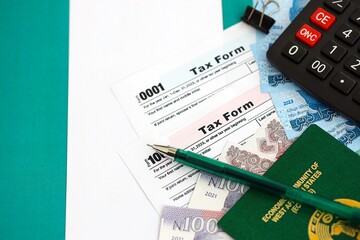 Nigerian naira money bills and calculator with tax form on flag. Taxation and accounting concept