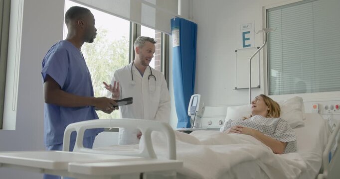 Two doctors consult with a female patient in a hospital room