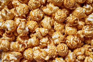 A generous serving of caramel popcorn showcases its shiny, golden coating. The texture invites a satisfying crunch, making it an ideal snack for gatherings or cozy nights in
