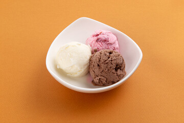 Three scoops of ice cream in a bowl.