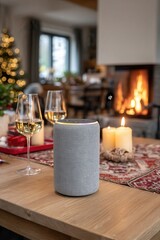 Smart home speaker glowing warmly with soft yellow light on dining table in cozy festive living room interior