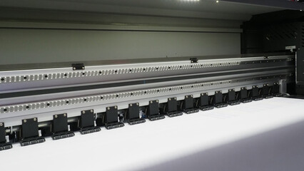 A close up of a large format inkjet printer in operation.