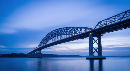 Naklejka premium Twilight View of Steel Arch Bridge Over Calm Water