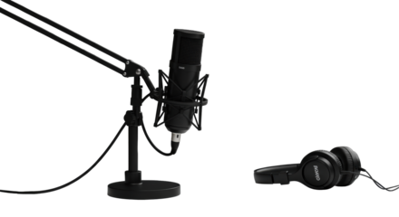 Sleek black condenser studio microphone on a boom arm & professional over-ear headphones on minimalist desk with blurred background. Concept of modern digital communication excellence