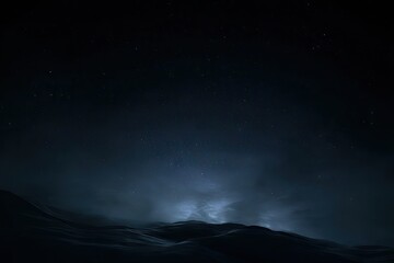Dark, star-studded night sky over misty mountains