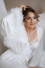 Elegant portrait of a woman in a white robe captured indoors during soft natural light