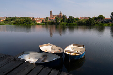 Fototapeta premium Salamanca Cathedral from the Tormes River port. Landscape view of the Tormes River as it passes through the city of Salamanca.