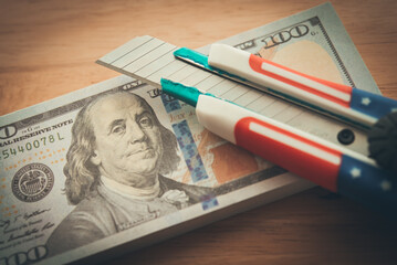 American flag cutter on US dollar banknotes. Central banking system of the United States FED (Federal Reserve System) cut interest rate to control monetary policy, world finance and economy concept.