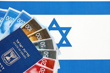 Israel New Shekels banknotes and passport on flag. The current Israel money bills and pass
