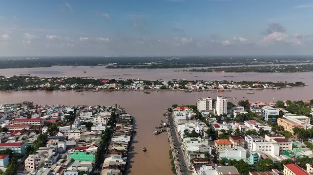 My Tho City, Dong Thap, Mekong Delta, Vietnam: 4K Aerial Drone View of Riverside Residential Area, Traditional and Modern Houses, Boats Docked Along Bao Dinh Canal, Tien River or Mekong River