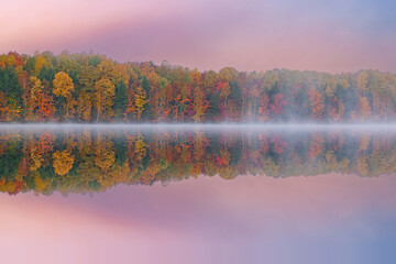 Foggy autumn landscape of the shoreline of Moccasin Lake with mirrored reflections in calm water, Hiawatha National Forest, Michigan's Upper Peninsula, USA