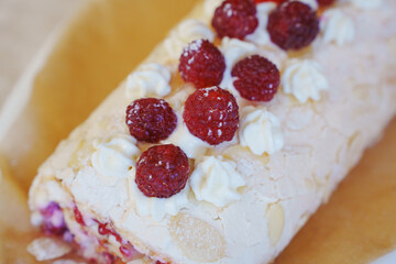 Delicious raspberry cream roll dessert displayed on a wooden board
