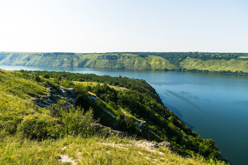 Calm waters and a green hill define the scenic beauty of Bakota Bay on the Dniester River, Ukraine.