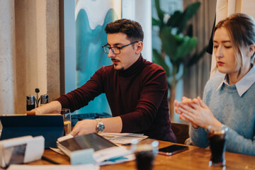 A group of people collaborating in a modern co working space, discussing strategies and planning ideas. The scene emphasizes teamwork, and a focused approach to sharing insights and innovations.