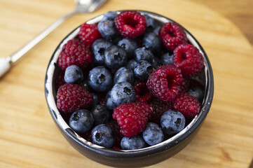 clay bowl with blueberries and raspberries