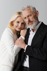 Stylish senior couple sharing a loving moment in chic outfits in a serene setting