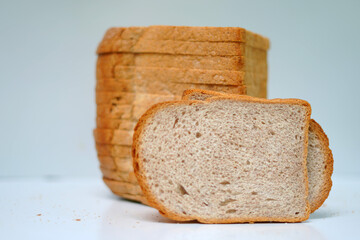 Fresh bakery loaf sliced on white surface.