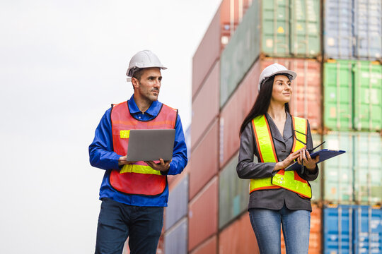 Logistics Engineers Collaborating at a Shipping Container Yard, Professional Port Workers Managing International Freight, Team of Industrial Workers Planning Supply Chain Operations - Powered by Adobe