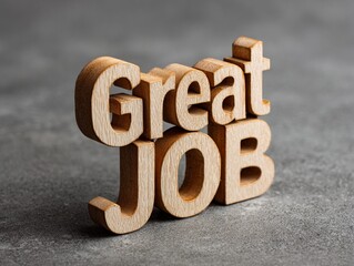 Wooden cutout letters spelling ' Great Job ' on a ashen background , conveying appreciation and encouragement .