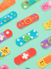 decorative plaster pattern with colorful adhesive bandages in diagonal rows on background for surface design