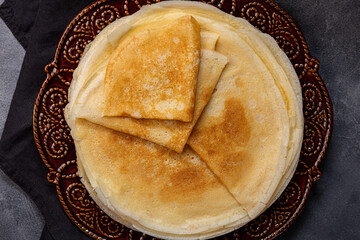 Thin pancakes on the grey background top view