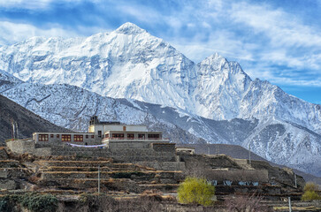 Tibetian House hight in Himalays with snowy mountain peak on background