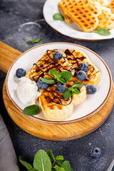 Thin pancakes with chocolate spread and blueberries on the grey background vertical photo