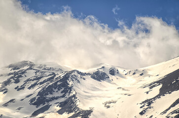 Cloud over snowy mountain