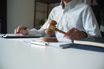 Legal justice man working on desk reading supportive documents to determine the case.