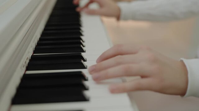 Focused young cute girl having fun playing electric piano. Musician teen student teaching music lesson. Home music studio woman. music education. Hands pressing the piano keys.
